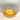 Eine Nahaufnahme zeigt eine helle, durchscheinende Glasschale, die mit einer Schicht klaren, goldgelben Agavendicksaft gefüllt ist. Der flüssige Dicksaft spiegelt das Licht, wodurch konzentrische Kreise auf der Oberfläche sichtbar sind. Die Schale steht auf einem hellen, weißen Hintergrund.